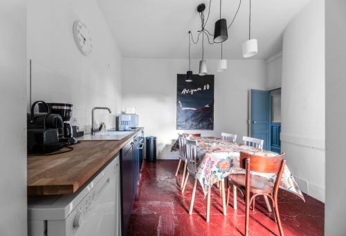 a kitchen with a table with chairs and a counter top at La Grande Maison Gannat in Gannat