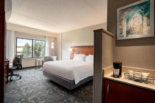 EwingにあるCourtyard Ewing Hopewellのベッドとデスクが備わるホテルルームです。