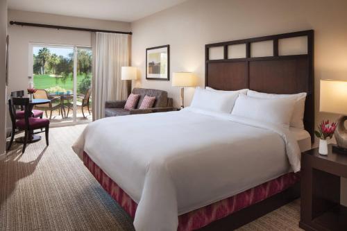 a bedroom with a large bed and a living room at Marriott's Shadow Ridge I - The Villages in Palm Desert