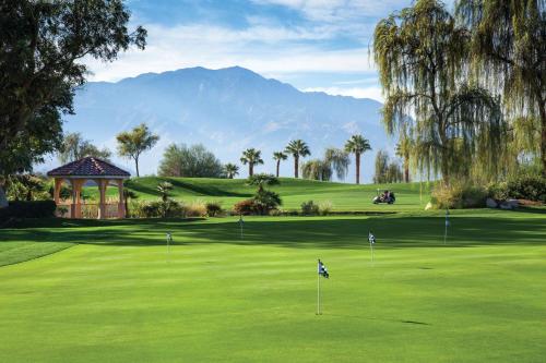 a green golf course with a gazebo and palm trees at Marriott's Shadow Ridge I - The Villages in Palm Desert