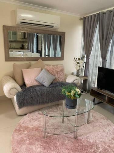 a living room with a couch and a glass table at Boutique Granny Flat in Paraparap