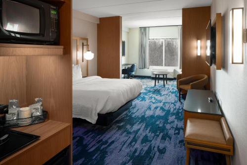 a hotel room with a bed and a television at Fairfield by Marriott Inn & Suites Somerset in Somerset