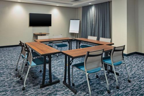 a conference room with tables and chairs and a flat screen tv at Fairfield by Marriott Inn & Suites Somerset in Somerset