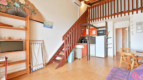 un salon avec un escalier et une cuisine dans l'établissement Les Indes Galantes- 270E- Studio vue mer- 5 pers, au Cap d'Agde