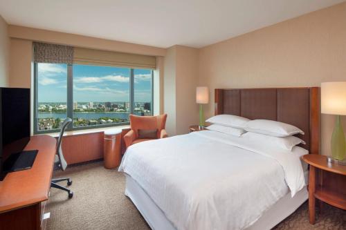 Habitación de hotel con cama grande y ventana grande. en Sheraton Boston Hotel, en Boston