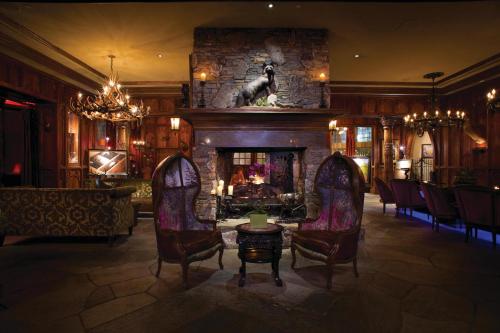 a living room with a stone fireplace and chairs at Grand Bohemian Hotel Asheville, Autograph Collection in Asheville
