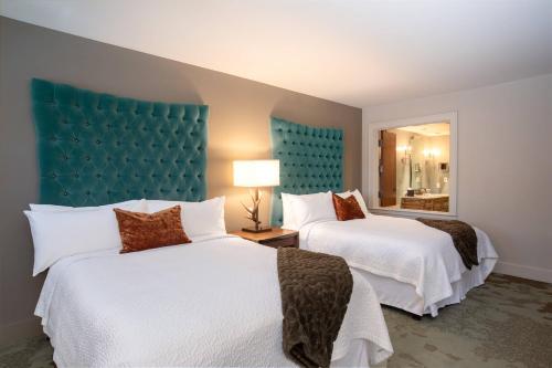 a hotel room with two beds and a blue headboard at Grand Bohemian Hotel Asheville, Autograph Collection in Asheville