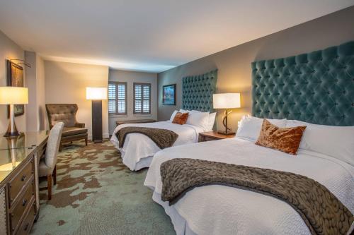 a hotel room with two beds and a chair at Grand Bohemian Hotel Asheville, Autograph Collection in Asheville