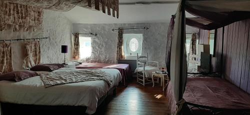 a bedroom with two beds and a table with a chair at Mas de la Filoselle in Saint-Martin-de-Valgalgues