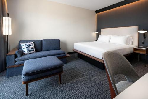 a hotel room with a bed and a chair at Courtyard by Marriott Fresno Clovis in Clovis