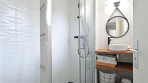a bathroom with a glass shower and a mirror at Terrasses de la Plage- 257- Appart moderne- 4 pers in Cap d'Agde