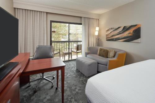 una camera d'albergo con letto, scrivania e sedia di Courtyard Chicago Wood Dale / Itasca a Wood Dale
