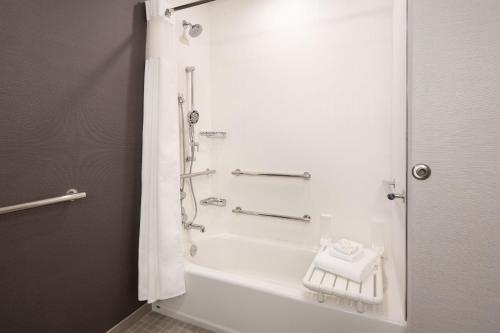 a bathroom with a shower and a bath tub at Courtyard by Marriott Fresno Clovis in Clovis