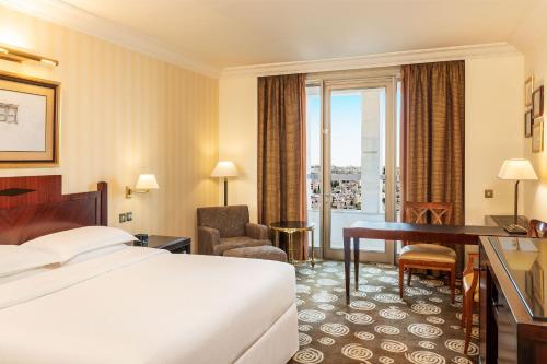 Sheraton Amman Al Nabil Hotel في عمّان: غرفة في الفندق مع سرير ومكتب