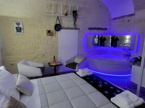 Un dormitorio con una bañera con luces moradas. en QUART0 GREC0 Suite 17, en Altamura