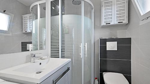 y baño blanco con lavabo y ducha. en Port Lano- 109- Appart lumineux- 4 pers, en Cap d'Agde