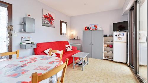 un salon avec un canapé rouge et une table dans l'établissement Port Lano- 109- Appart lumineux- 4 pers, au Cap d'Agde