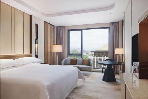 a hotel room with a bed and a large window at Sheraton Yunfu Xinxing Hotel in Yunfu