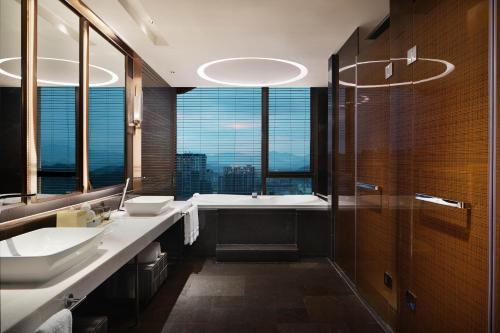a bathroom with two sinks and a tub with a window at Sheraton Yunfu Xinxing Hotel in Yunfu