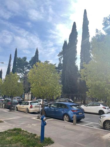 um carro azul estacionado num parque de estacionamento com carros em Apartment Downtown em Podgorica