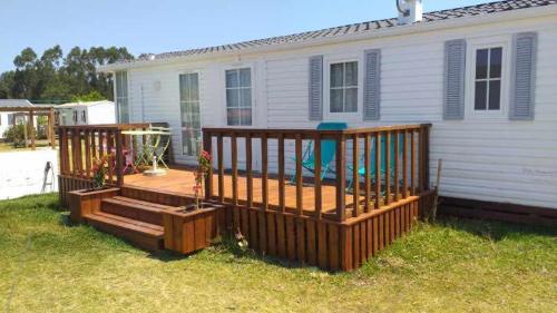 a wooden deck in front of a house at Bungalow au bord de la piscine 4 pers 5A in Burinhosa