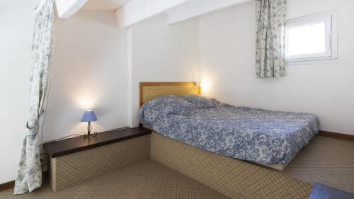 um pequeno quarto com uma cama e uma janela em Aquaplage- 105B- Studio vue mer- 5 pers em Cap d'Agde