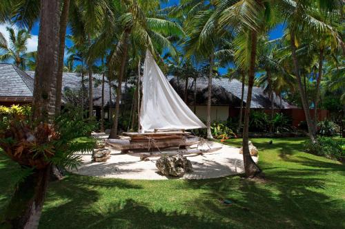 a hammock with a sail in a yard with palm trees at Le Méridien Ile des Pins in Oro Bay