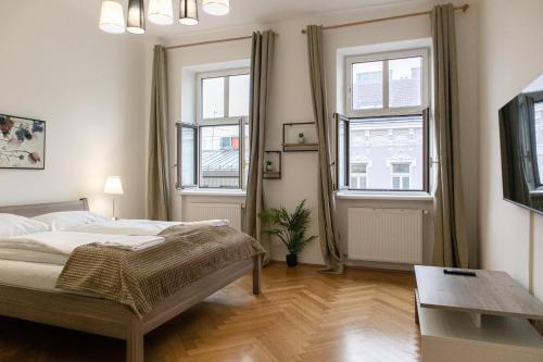 a bedroom with a bed and two windows at comfortable 2BR Apt.-Near Wiener Stadthalle in Vienna