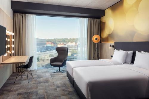 Pokój hotelowy z 2 łóżkami, biurkiem i oknem w obiekcie STAGES HOTEL Prague, a Tribute Portfolio Hotel w Pradze