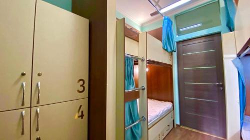 - une petite chambre avec des lits superposés et un placard dans l'établissement Golden Square, à Almaty