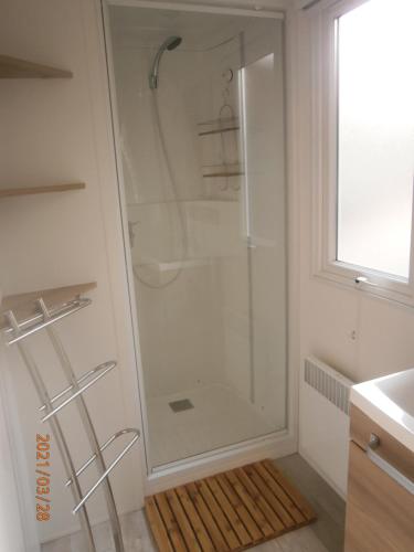 a shower with a glass door in a bathroom at Mobilhome 3 chambres tout confort, proche de la plage in Saint-Brevin-les-Pins