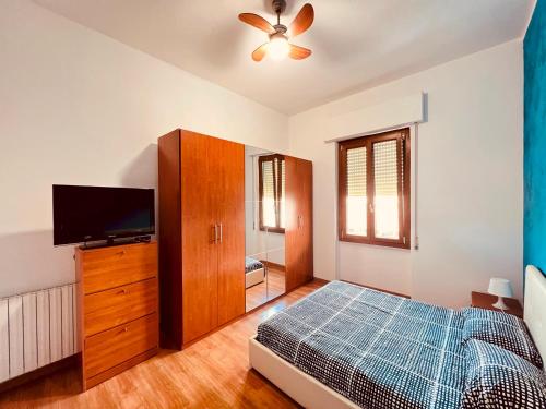 Schlafzimmer mit einem Bett und einem Flachbild-TV in der Unterkunft Be Your Home - Casa Vacanze Il Posticino in Civitavecchia