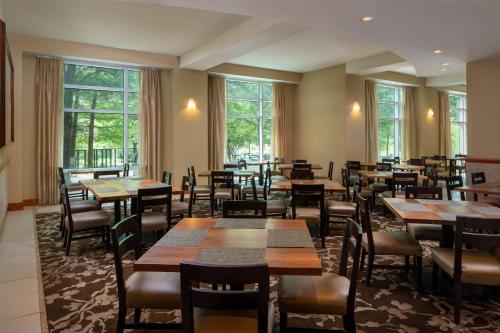 um restaurante com mesas, cadeiras e janelas em The Woodlands Waterway Marriott Hotel and Convention Center em The Woodlands