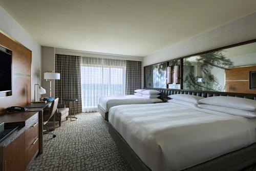 a hotel room with two beds and a television at The Woodlands Waterway Marriott Hotel and Convention Center in The Woodlands