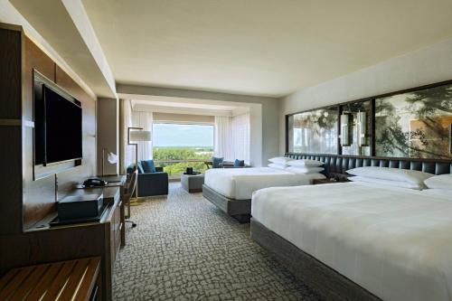 a hotel room with two beds and a flat screen tv at The Woodlands Waterway Marriott Hotel and Convention Center in The Woodlands