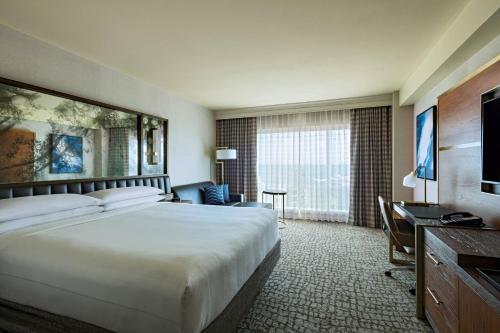a hotel room with a bed and a desk and a television at The Woodlands Waterway Marriott Hotel and Convention Center in The Woodlands