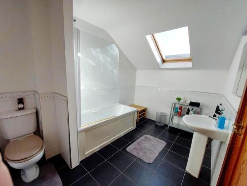 y baño con bañera, aseo y lavamanos. en Private accommodation in house close to Galway City, en Galway