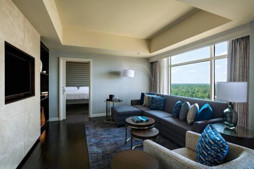 a living room with a couch and a large window at The Woodlands Waterway Marriott Hotel and Convention Center in The Woodlands