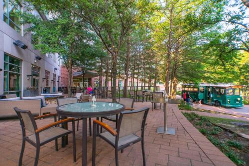 a patio with tables and chairs and a bus at The Woodlands Waterway Marriott Hotel and Convention Center in The Woodlands