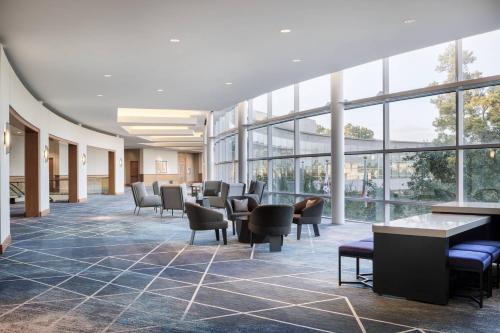 a lobby with chairs and tables and windows at The Woodlands Waterway Marriott Hotel and Convention Center in The Woodlands