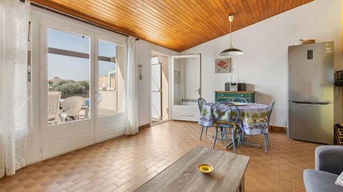un salon avec une table et un réfrigérateur dans l'établissement Port La Roquille- 106- Appart lumineux- 6 pers, au Cap d'Agde