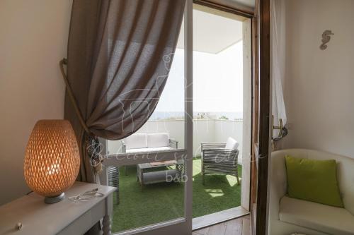a living room with a sliding glass door to a patio at Balconi sul mare in Otranto