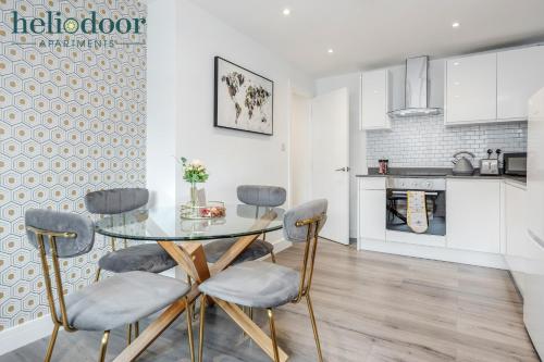 a kitchen with a glass table and four chairs at HAML Heliodoor Apartments Milton Keynes, Free Parking, Free WiFi & Movies, 7-min drive to City Centre in Wolverton