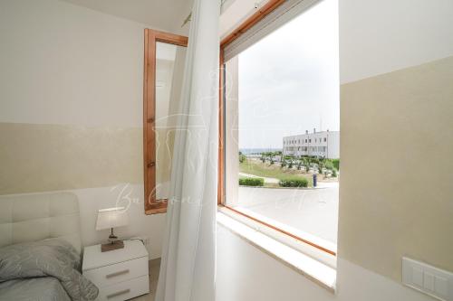 a bedroom with a window with a view of the ocean at Balconi sul mare in Otranto