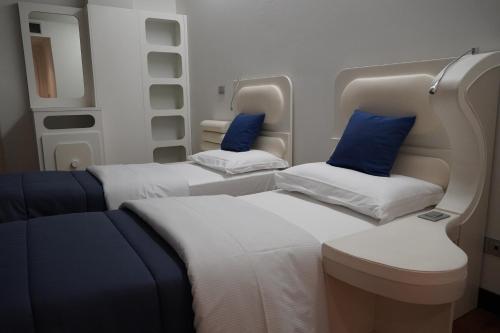two beds in an airplane with blue pillows at Residence Prestige in Gorgonzola