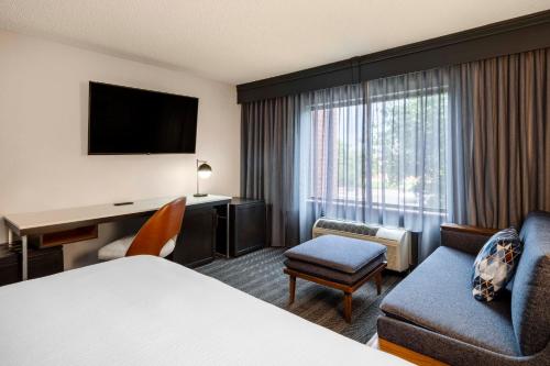 a hotel room with a bed and a desk and a chair at Courtyard Denver Southwest/Lakewood in Lakewood