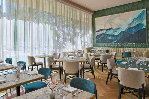 a restaurant with tables and chairs and a large painting at The St. Regis San Francisco in San Francisco