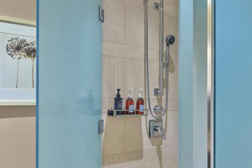 a shower with bottles of alcohol on a shelf in a bathroom at The St. Regis San Francisco in San Francisco
