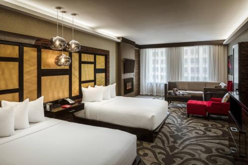 a hotel room with two beds and a living room at Metropolitan at The 9, Autograph Collection in Cleveland