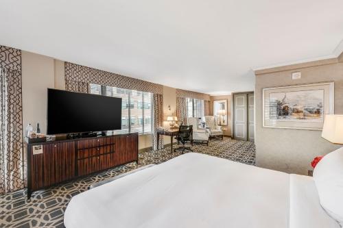 a hotel room with a bed and a flat screen tv at The Madison Hotel in Washington, D.C.